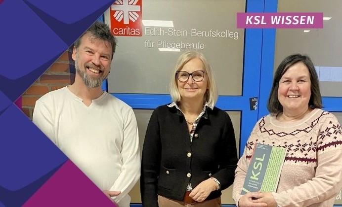 Eingerahmt in das KSL-Design aus blauen und rosafarbenen Kacheln lächeln Oliver Schneider vom KSL.Münster (in einem weißen Langarm-Shirt mit grau melierten Haaren und Bart) sowie Beate Bruns-Schneider (mit halblangen, blonden Haaren, Brille und dunklem Blazer) und Cornelia Lückener-Korte (in einem beigen Strickpullover mit rotem Geo-Muster sowie halblangen, braun-grauen Haaren) in die Kamera. Letztere hält die Broschüre KSL-Konkret Nr. 4 „Vielfalt Pflegen“ in der Hand und im Hintergrund ist eine breite Schul-Tür mit der Aufschrift „Edith-Stein-Berufskolleg für Pflegeberufe“ und dem caritas-Logo zu sehen.