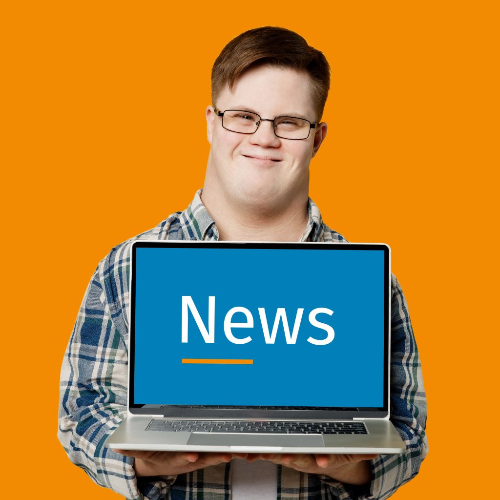 Junger Mann mit Behinderung hält einen Laptop mit dem Wort „News“ auf dem Bildschirm