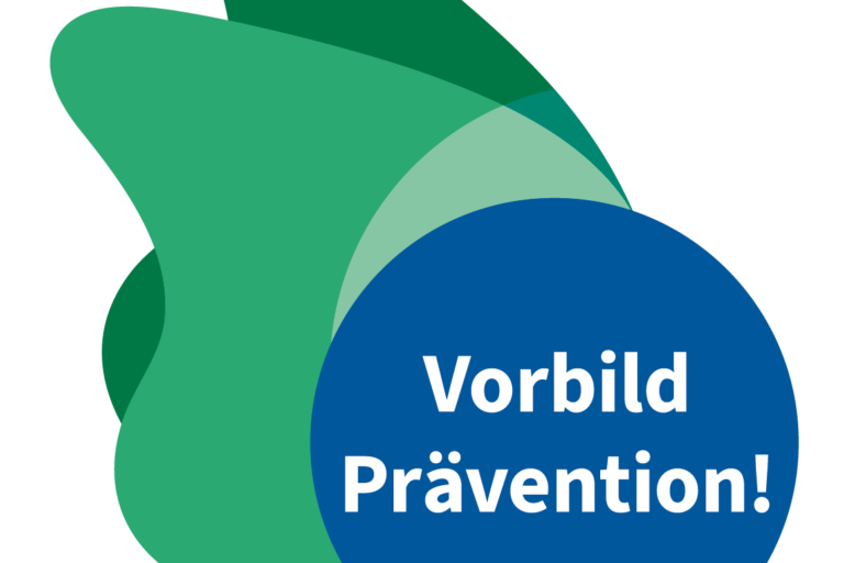 Das Logo der Auszeichnung besteht aus einem blauen Kreis mit weißem Schriftzug „Vorbild Prävention!“ und zwei grünen Elementen, die linksseitig wie zwei Flügel andocken.