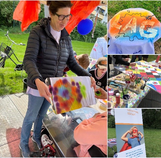 Die Collage zeigt Impressionen von den Aktivitäten am Gemeinschaftsstand der LAG Selbsthilfe NRW mit den zugehörigen Projekten: Geschäftsführerin Melanie Ahlke hält einer Teilnehmerin im E-Rolli einen auf Pappe gespannten Schlauchschal hin, sodass diese ihn bunt besprühen kann. Auch die Helfer*innen-T-Shirts wurden individuell gestaltet – wie hier mit dem LAG-Schriftzug in Regenbogenfarben. Auf einem großen Tisch voller Farbtöpfe mit Pinseln malen mehrere Besucher*innen kleine Quadrate einer Leinwand aus, aus denen ein großes Gesamtkunstwerk entsteht. Neben dem Wäscheständer, auf dem die kreativen Textilien trocknen, steht das Roll-Up der LAG Selbsthilfe NRW, das passend zum Motto „Gemeinsam stärker“ ein Mädchen im Superheld*innen-Umhang zeigt.