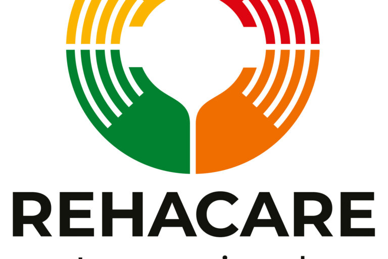 Das Logo der Messe zeigt vier in einander greifende Hände, die zusammen einen Kreis in den Farben Grün, Gelb, Orange und Rot bilden. Darunter stehen in schwarzer Schrift die Informationen: REHACARE International Fachmesse für Rehabilitation und Pflege - Düsseldorf, 23. bis 26. September 2026