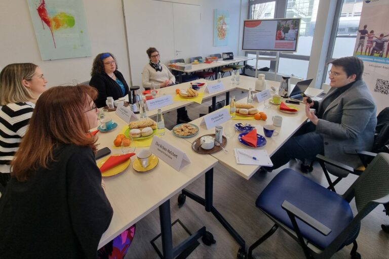 Gemeinsam an einem Tisch: Kreis-Dezernentin Elke Ricken-Melchert, Amtleiterin Claudia Küpper, Kreis-Inklusionsbeauftragte Emily Willkomm-Laufs und Melanie Ahlke, Geschäftsleitung LAG Selbsthilfe NRW hören interessiert der Wissenschaftlichen Referentin des Projekts In Zukunft Inklusiv, Clara Lenkeit, zu.