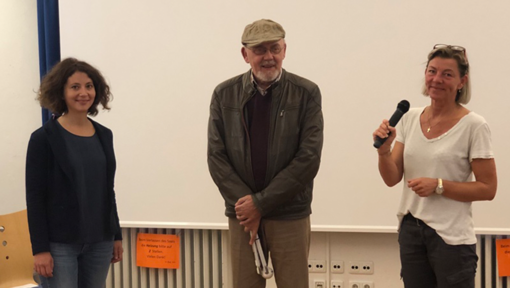 Die Leiterin des Projekts "Politische Partizipation Passgenau!", Merle Schmidt, gemeinsam mit dem Vorsitzenden des Herforder Beirats für Menschen mit Behinderung, Hans-Gerd Adolphy, und Beriatsmitglied Claudia Raukohl lächeln in die Kamera. Frau Raukohl hält ein Mikrofon in der Hand.