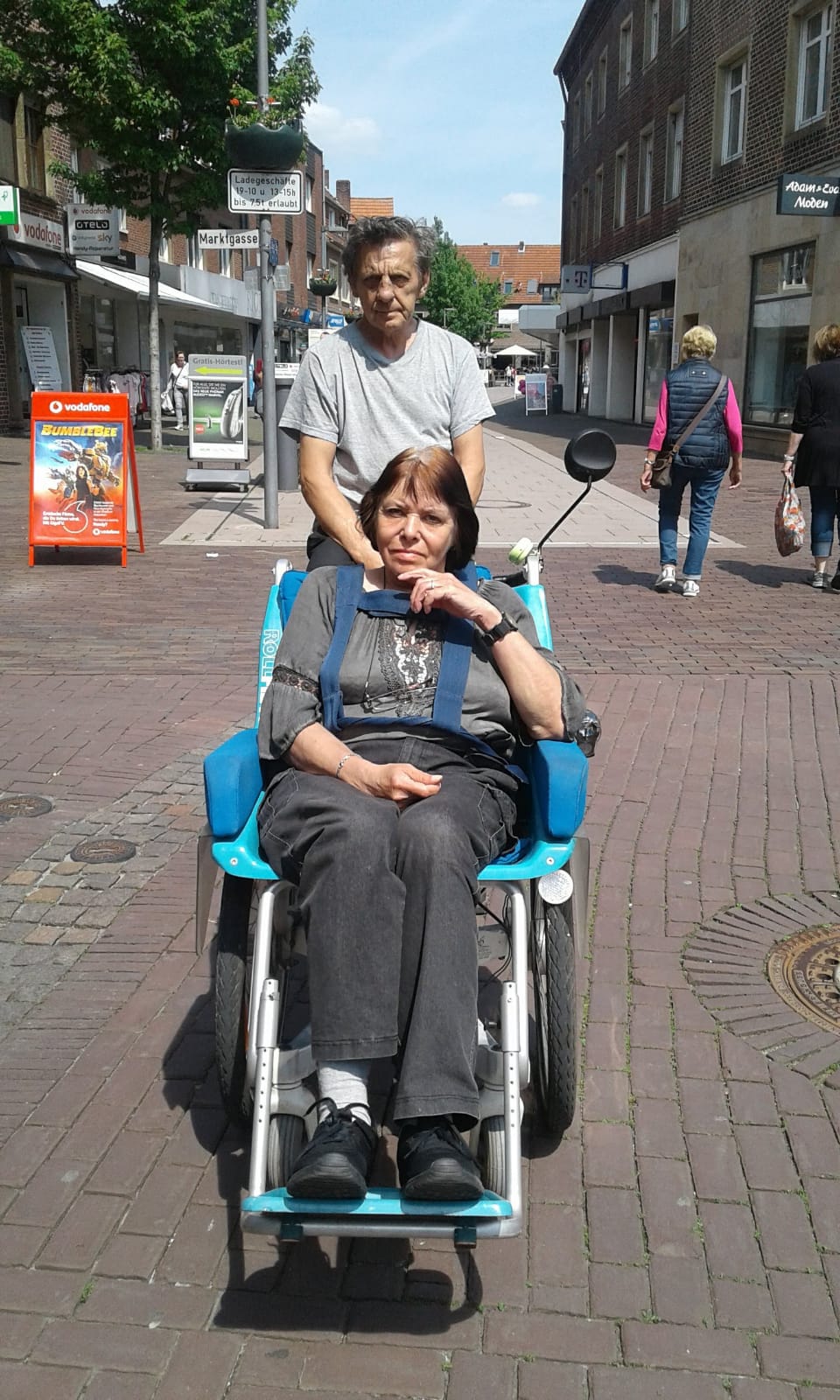 Foto von Herr und Frau König mit ihrem besonderen Tandem Fahrrad. Frau König sitzt vorne in einem Sitz. Herr König fährt das Rad.